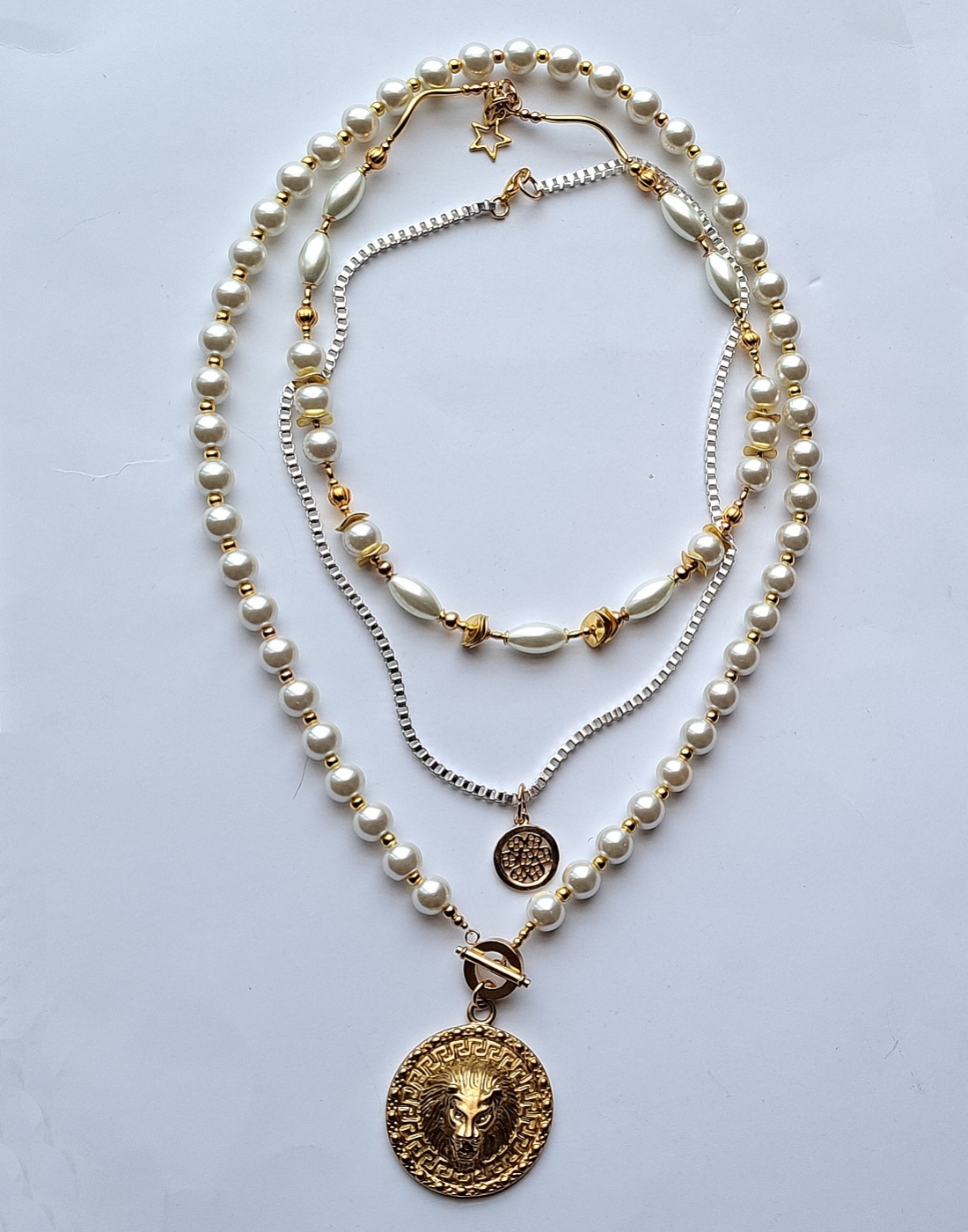 kompozycja 3 oddzielnych naszyjników w duchu biżuterii Boho z mixu szklanych pereł i ozdób typu bali w kolorze złota